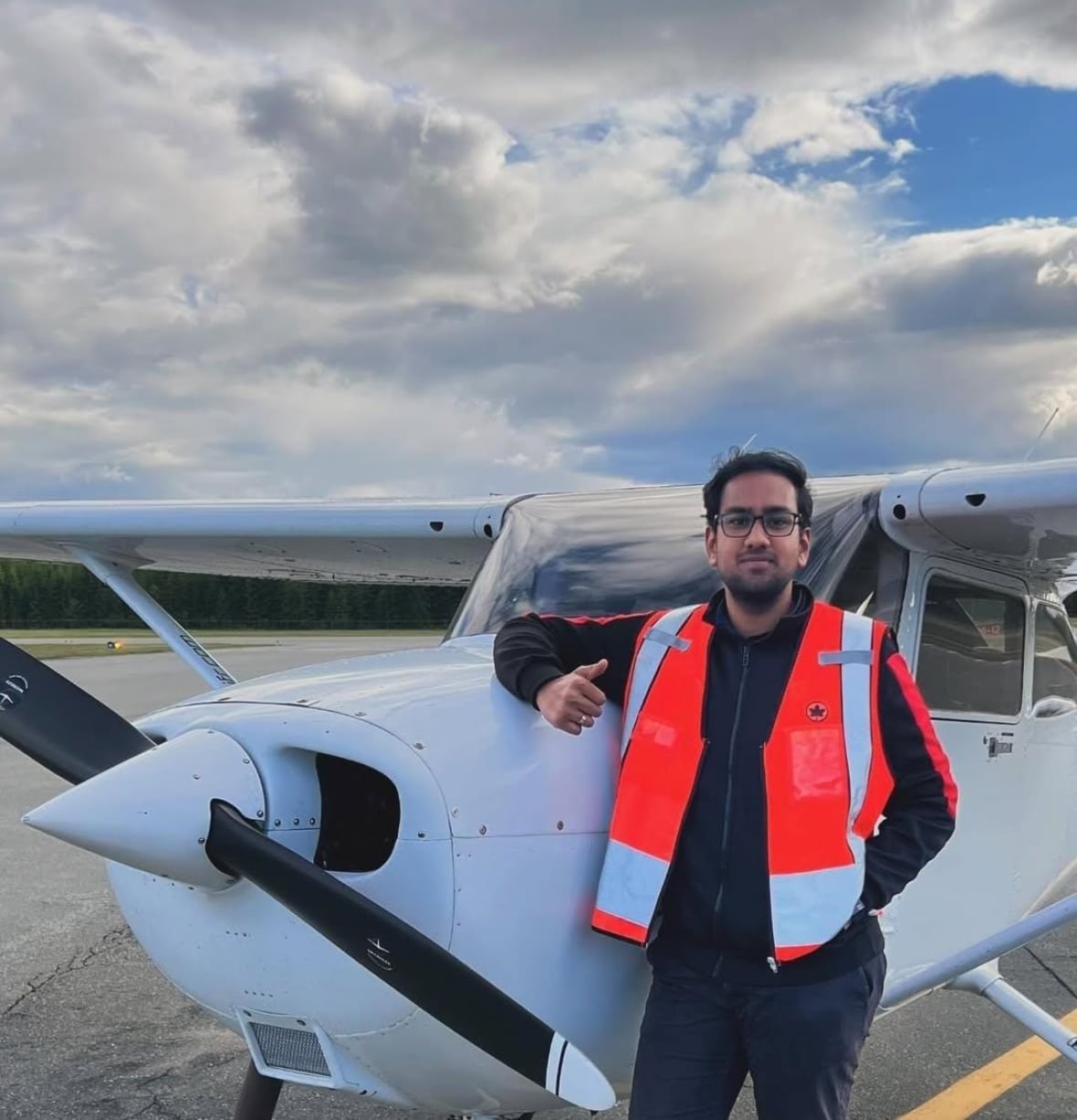 Man standing by small plane smiling
