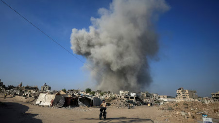 A Palestinian man rides a bike as smoke rises following an Israeli strike, in Gaza City, August 24, 2025. REUTERS/Dawoud Abu Alkas