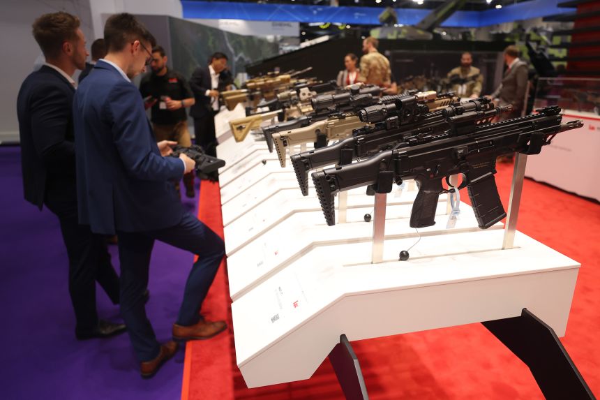 A visitor tries a range of assault rifles at DSEI 2023.