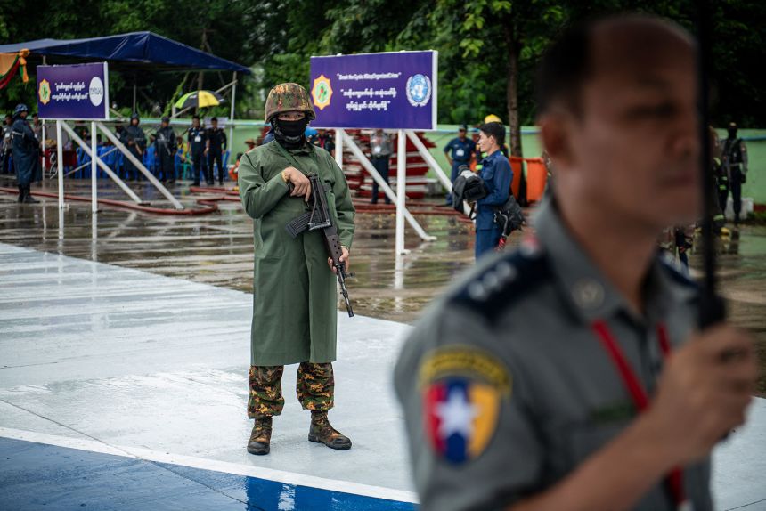 A military soldier (L) stands in front of a pile of seized illegal drugs during a destruction ceremony in Yangon on June 26, 2025.