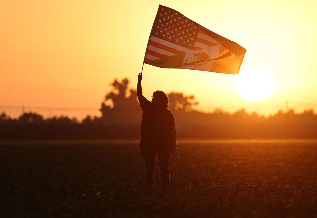 A woman waves an American-Mexican flag in a protest of immigration raids near Camarillo, California, on July 10.