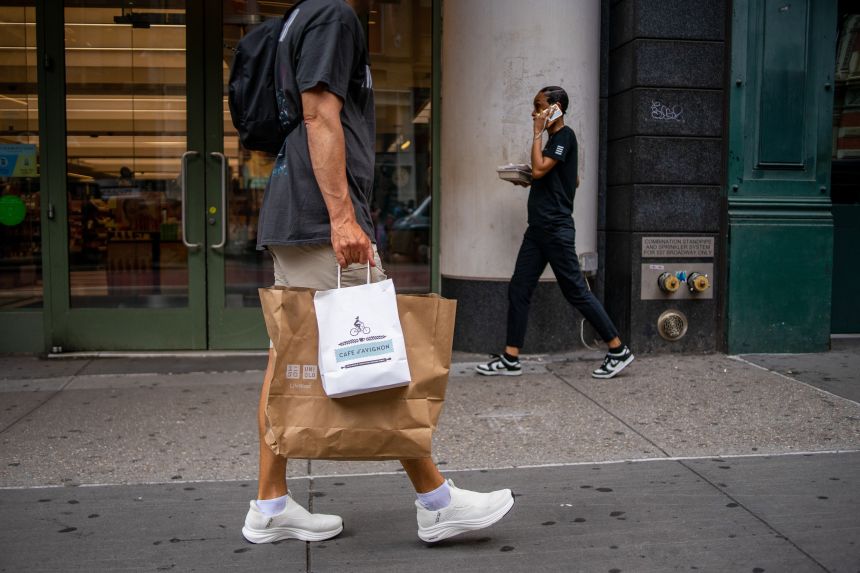 A shopper carrying bags on Broadway.