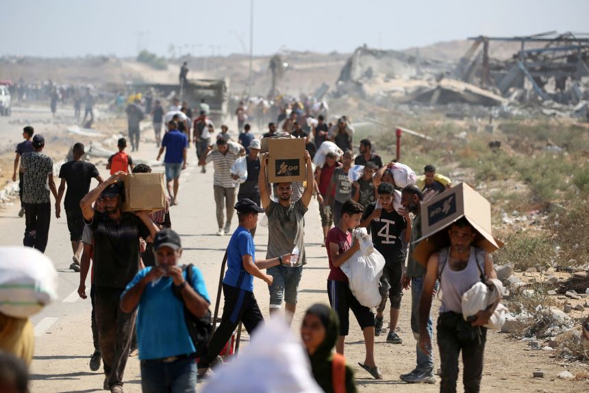 Palestinians leave a food distribution point run by the US and Israeli-backed Gaza Humanitarian Foundation (GHF), near the Netzarim Corridor in the central Gaza Strip on August 3, 2025.