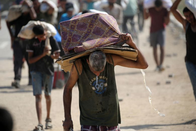 A man carries cardboard boxes as he returns from a food distribution site near the Netsarim corridor in the central Gaza Strip on August 3.