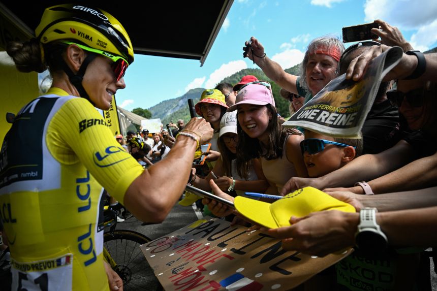 Pauline Ferrand-Prévot signs autographs in front of her team bus, ahead of the start of the final stage.