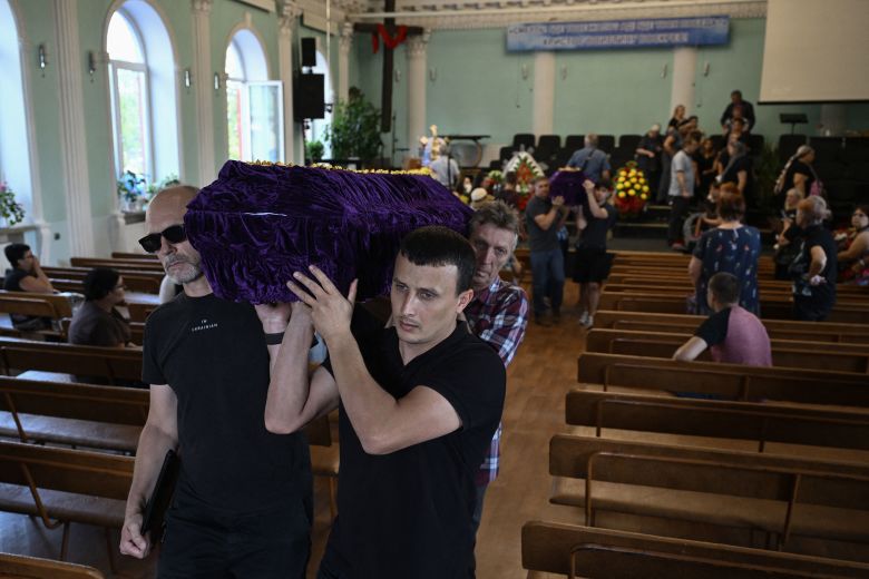 Pallbearers carry coffins following a funeral ceremony for a couple and their son, in a church in Sloviansk, Ukraine, on August 5.