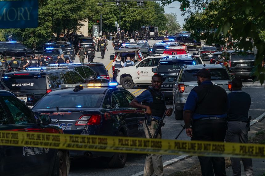 Law enforcement is seen near the CDC headquarters during an incident where a police officer was injured and later died at a hospital. The shooter was also dead.