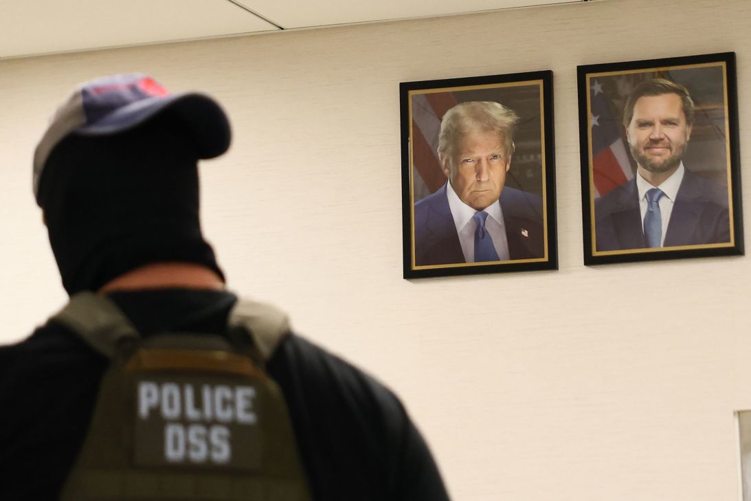 A federal agent walks past portraits of President Donald Trump and Vice President JD Vance at a federal building in New York City on August 4.