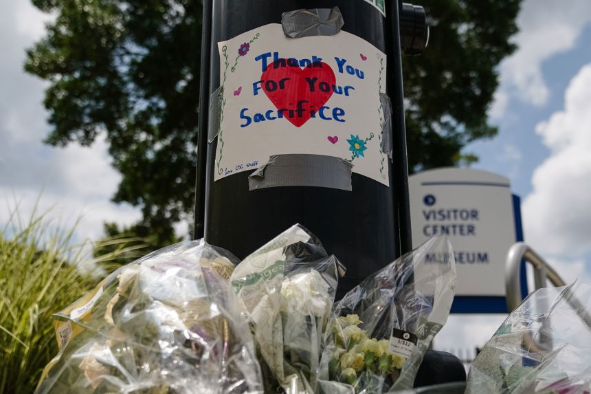 Flowers are seen below a handwritten sign outside the Centers For Disease Control (CDC) Global Headquarters following a shooting on August 9, 2025, in Atlanta, Georgia.