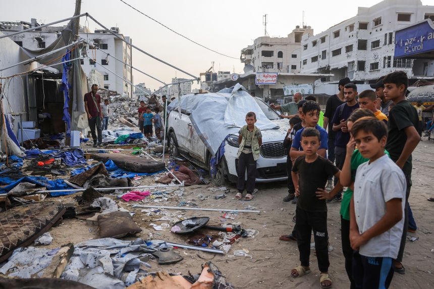 Palestinians stand near the destroyed Al Jazeera tent at Al-Shifa Hospital in Gaza City on August 11, 2025, following an overnight strike by the Israeli military.