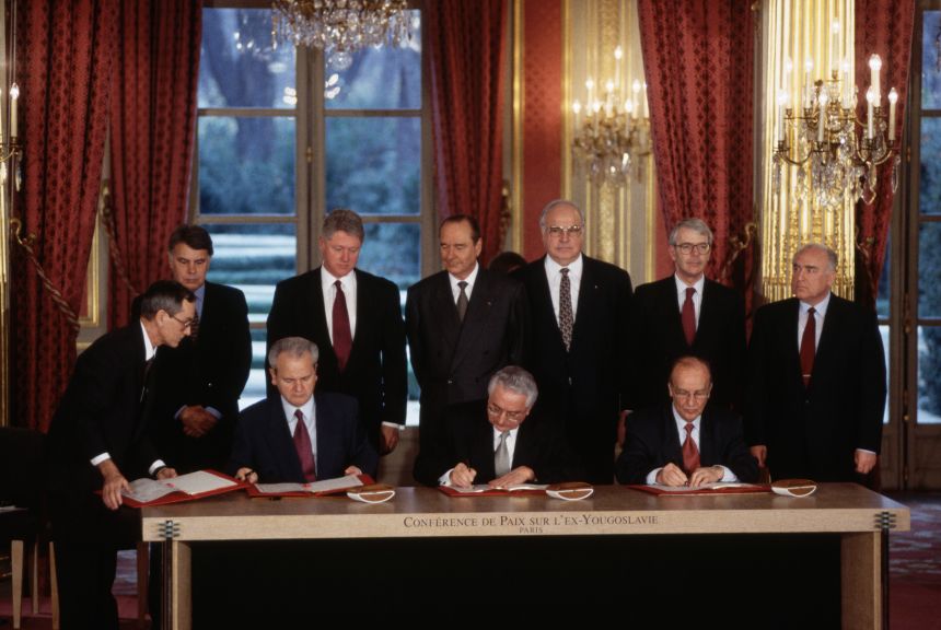 Leaders of six nations look on as the presidents of Serbia, Croatia and Bosnia sign the Dayton Peace Accords at the Élysée Palace in France, December 1995.
