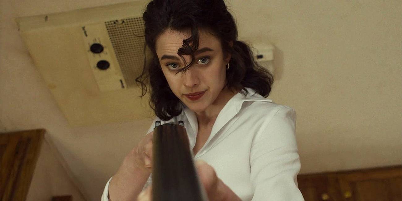Margaret Qualley holding a shot gun at the camera in Honey Don't!
