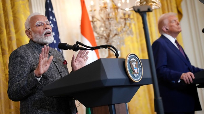 Prime Minister Narendra Modi speaks at a podium as US President Donald Trump stands beside him during a joint press conference in Washington in February