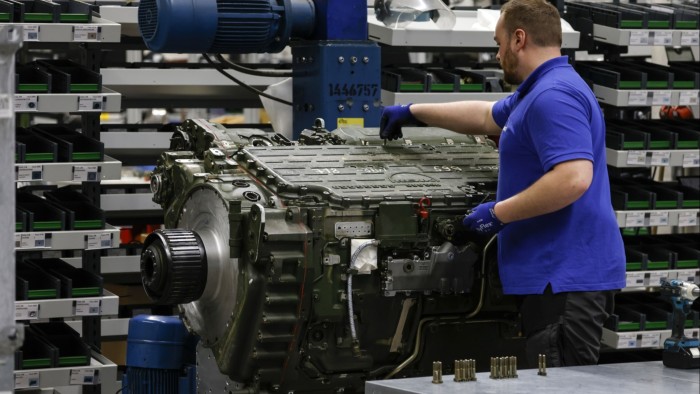 An employee works on a Leopard 2 tank gear transmission inside a production hall at the Renk plant.