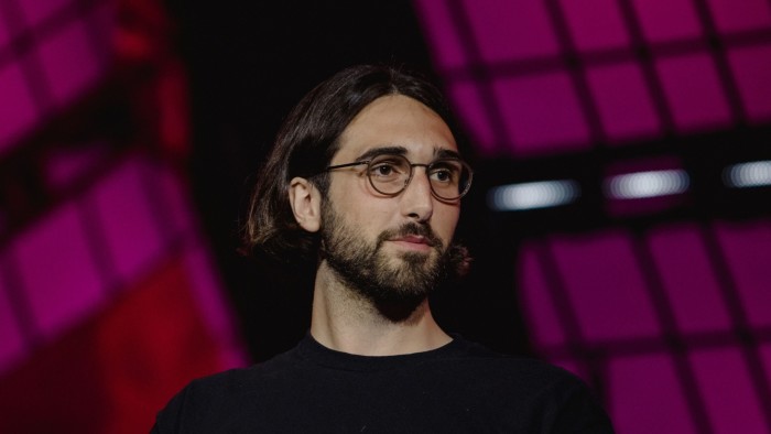 chief executive Aidan Gomez listens at a conference