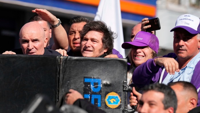 Police shield Argentine President Javier Milei from objects thrown during a campaign rally