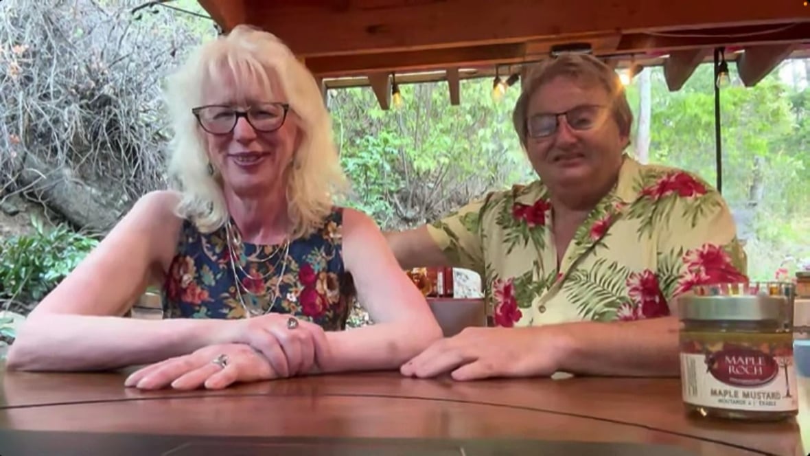 A woman with white-blond hair and a floral top and a man with grey hair and a Hawaiian button-down smile in a Zoom call screenshot. 