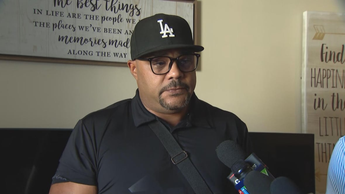 Man in a black polo short and black baseball hat