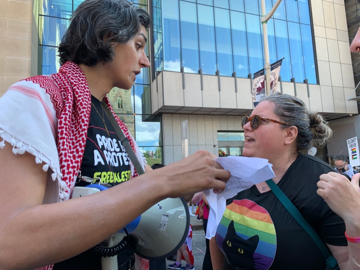Two people arguing outside at a protest.