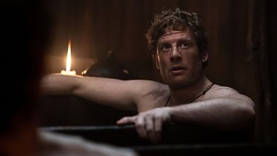 Harold Earl of Wessex (James Norton) is central in the image. He is staring off into the distance while a candle burns behind him