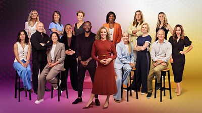 A group shot of 16 presenters against a colourful background of pink yellow and purple hues.  Some are stood and some are sat down. All of them are smiling.