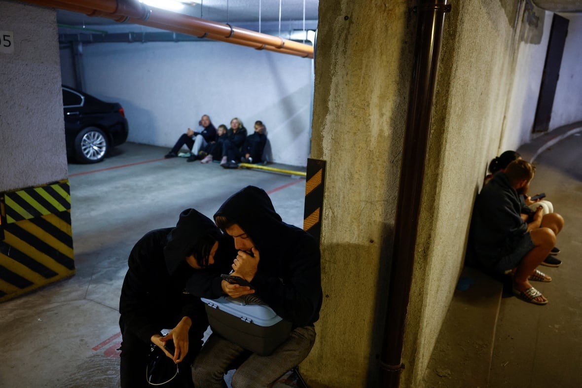 People are seen taking shelter inside a parking garage in Kyiv, Ukraine, amid a Russian drone and missile attack.