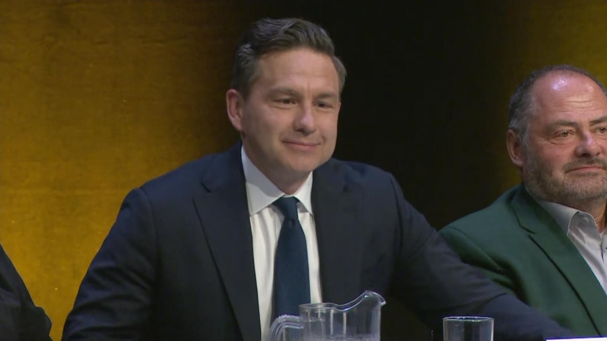 A man wearing a suit and tie smiles at the camera.