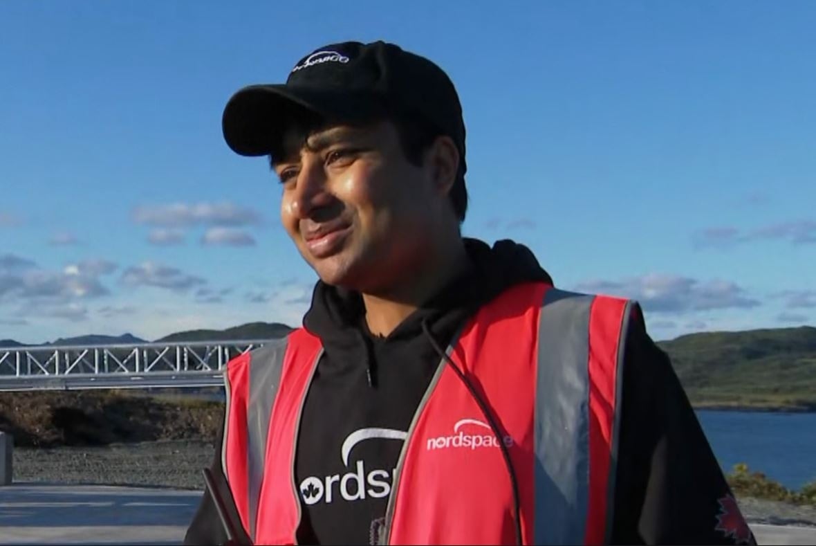 A man wearing a safety vest and black hoodie. Both have the logo for NordSpace on them.