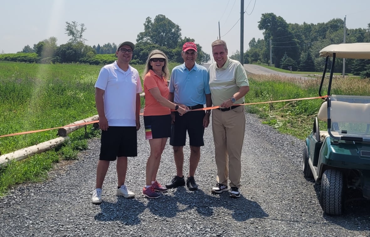 A group of people cutting a ribbon