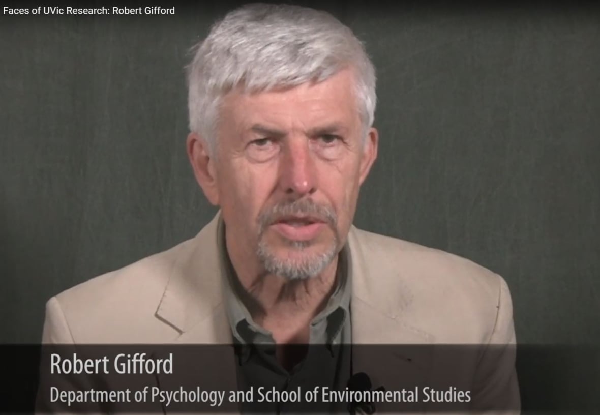 A man with a full head of white hair in a beige suit over a grey shirt looks straight into the camera in this head-and-shoulders shot. Underneath a banner displays, 'Robert Gifford, Department of Psychology and School of Environmental Studies.'
