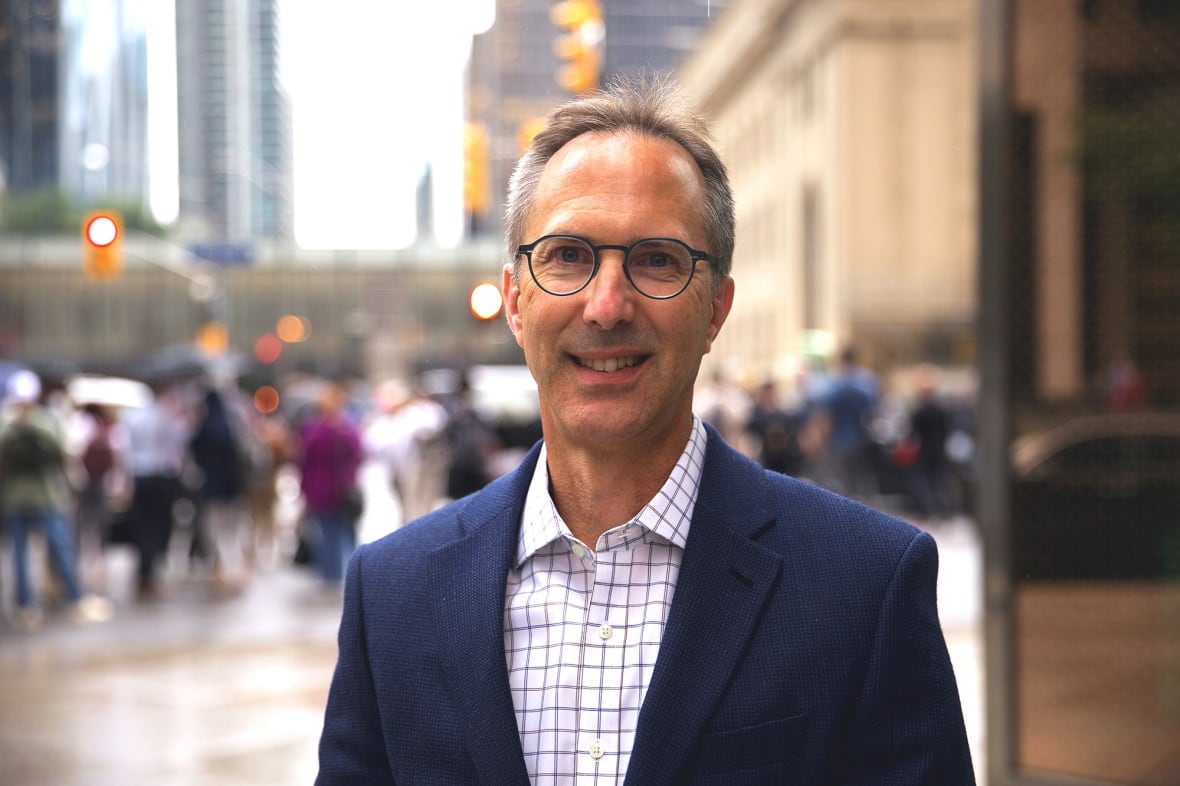 A man in a suit jacket on a busy urban street.