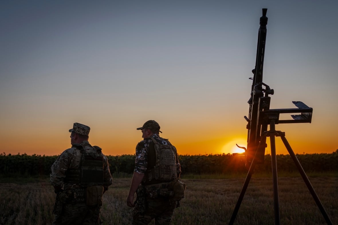 Ukrainian servicemen of the 15th Army Corps stand by an armed pickup truck during night duty in the Chernihiv region, Ukraine, late Tuesday, Aug. 12, 2025.