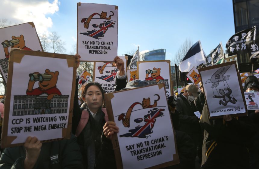 Protesters hold placards during a demonstration outside the former Royal Mint site in London on March 15.