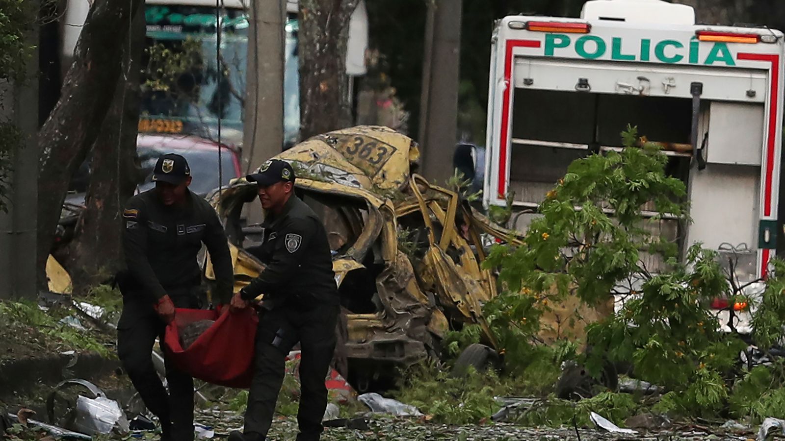 Police remove wreckage from the site of a bomb explosion outside an Air Force base in Cali, Colombia. Pic: AP