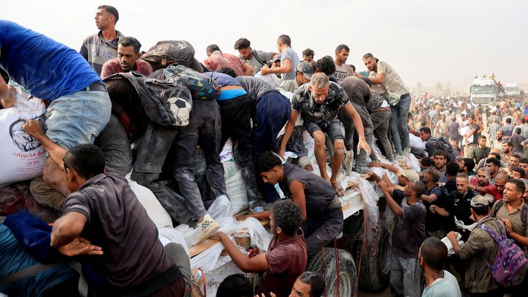 Palestinians scramble to collect aid from trucks in Khan Younis, southern Gaza. Pic: Reuters