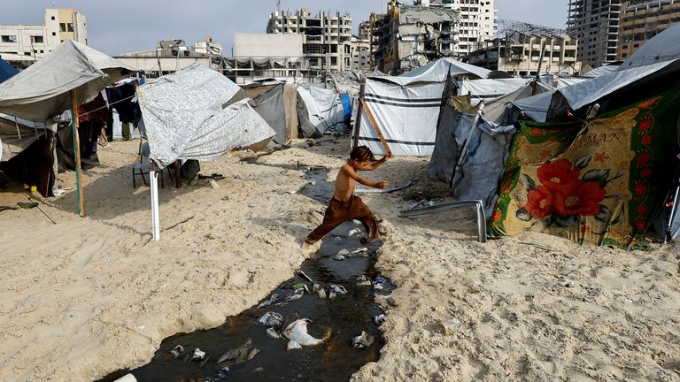 A Palestinian boy jumps over wastewater in Gaza City. Pic: Reuters