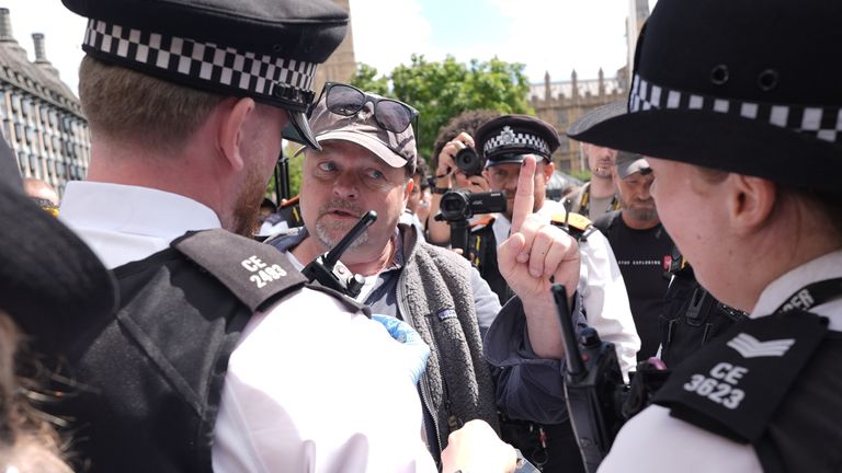 A man is detained by police officers in Parliament Square. Pic: PA