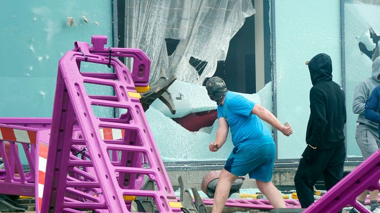 Windows are smashed as trouble flares during an anti-immigration protest outside the Holiday Inn Express in Rotherham, South Yorkshire. Picture date: Sunday August 4, 2024. PA Photo. See PA story POLICE Southport. Photo credit should read: Danny Lawson/PA Wire