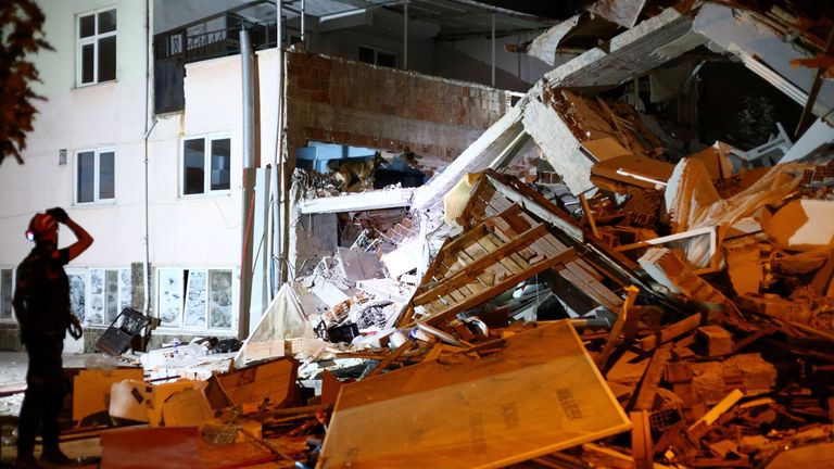 Rescuers called for silence to help them hear signs of life beneath the rubble. Pic: Reuters
