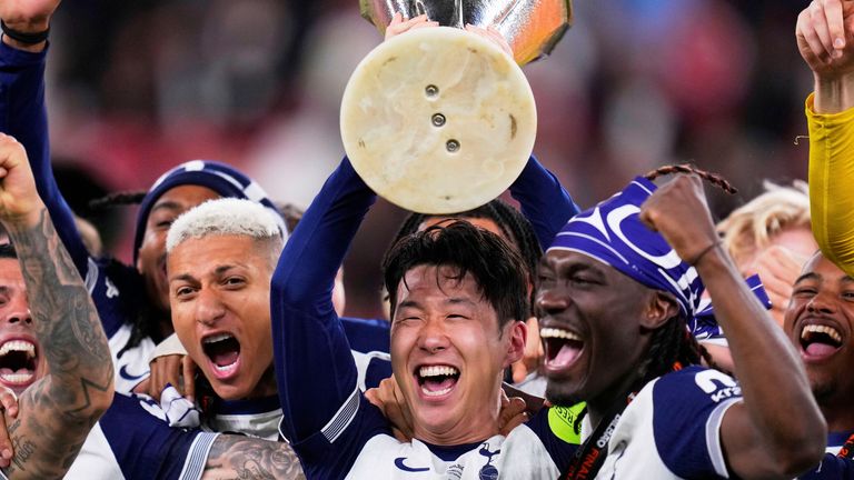 Tottenham's Son Heung-min holds the trophy aloft as he celebrates with teammates after winning the Europa League final soccer match against Manchester United at the San Mames Stadium in Bilbao, Spain, Wednesday, May 21, 2025. (AP Photo/Manu Fernandez)