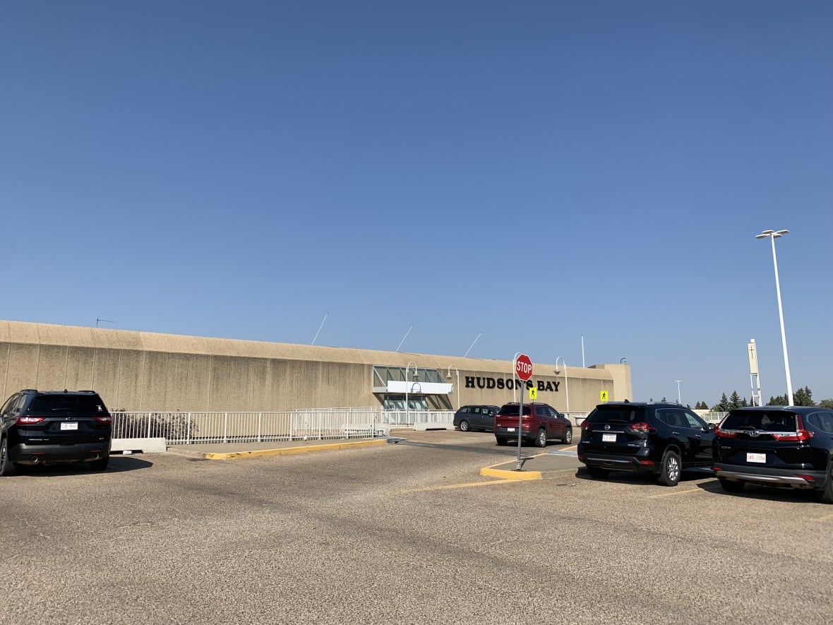 A photo of a brown Hudson's Bay building, taken from the parking lot.