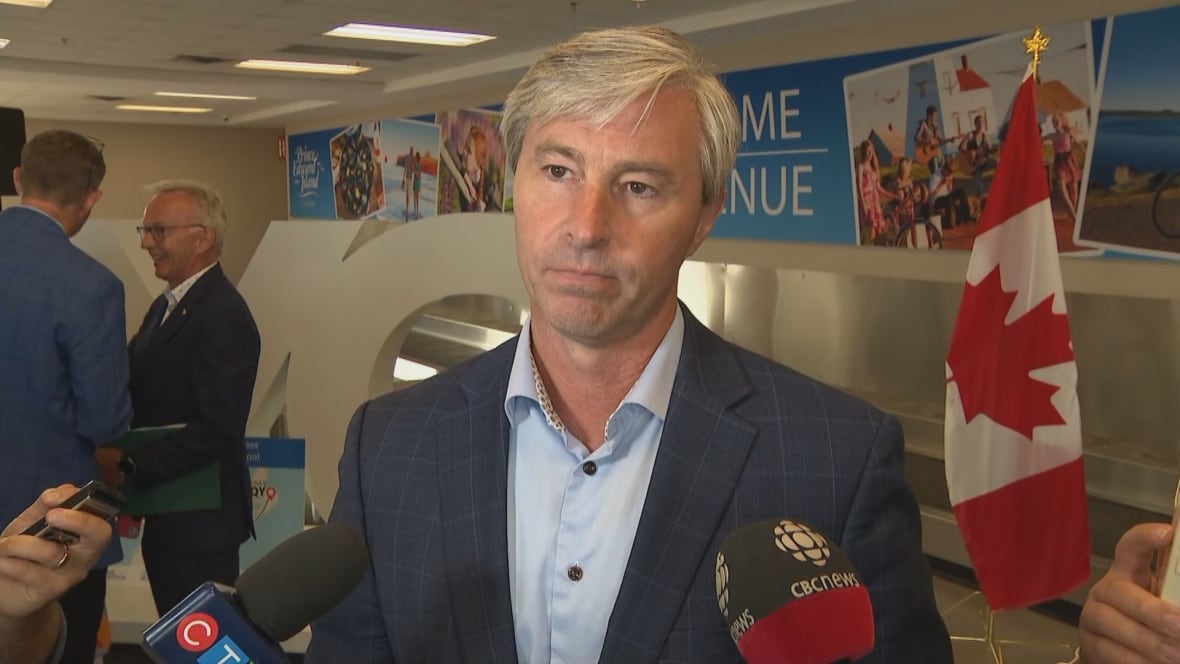 Man in suit with Canadian flag over his right shoulder