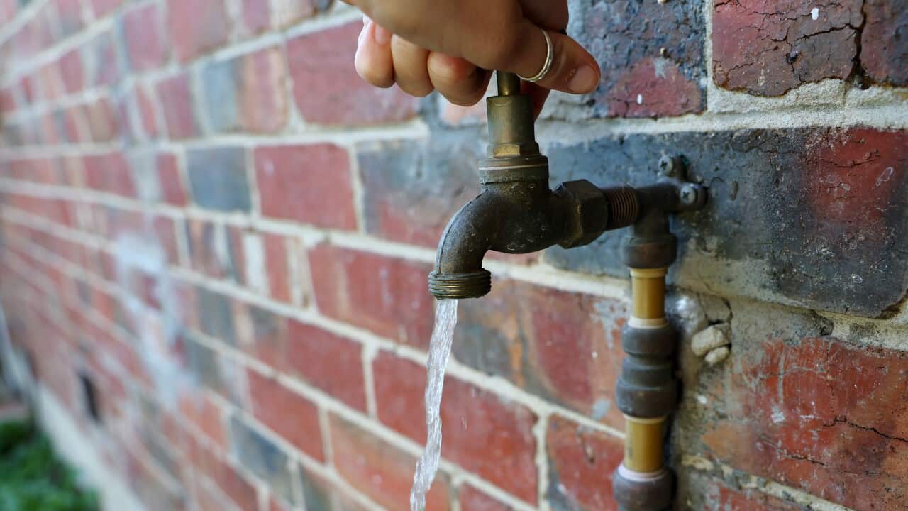 A hand turning on a tap