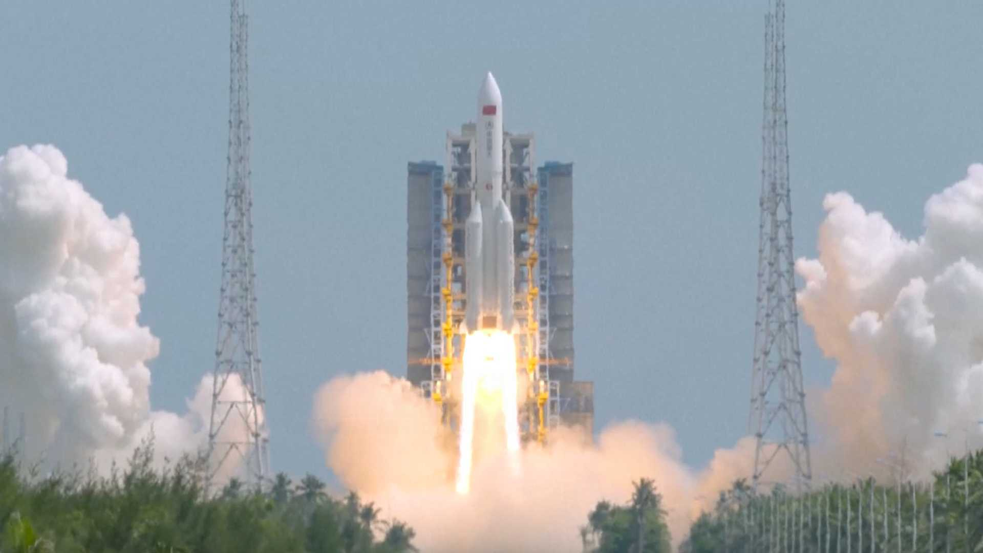 a large white rocket launches into a blue sky