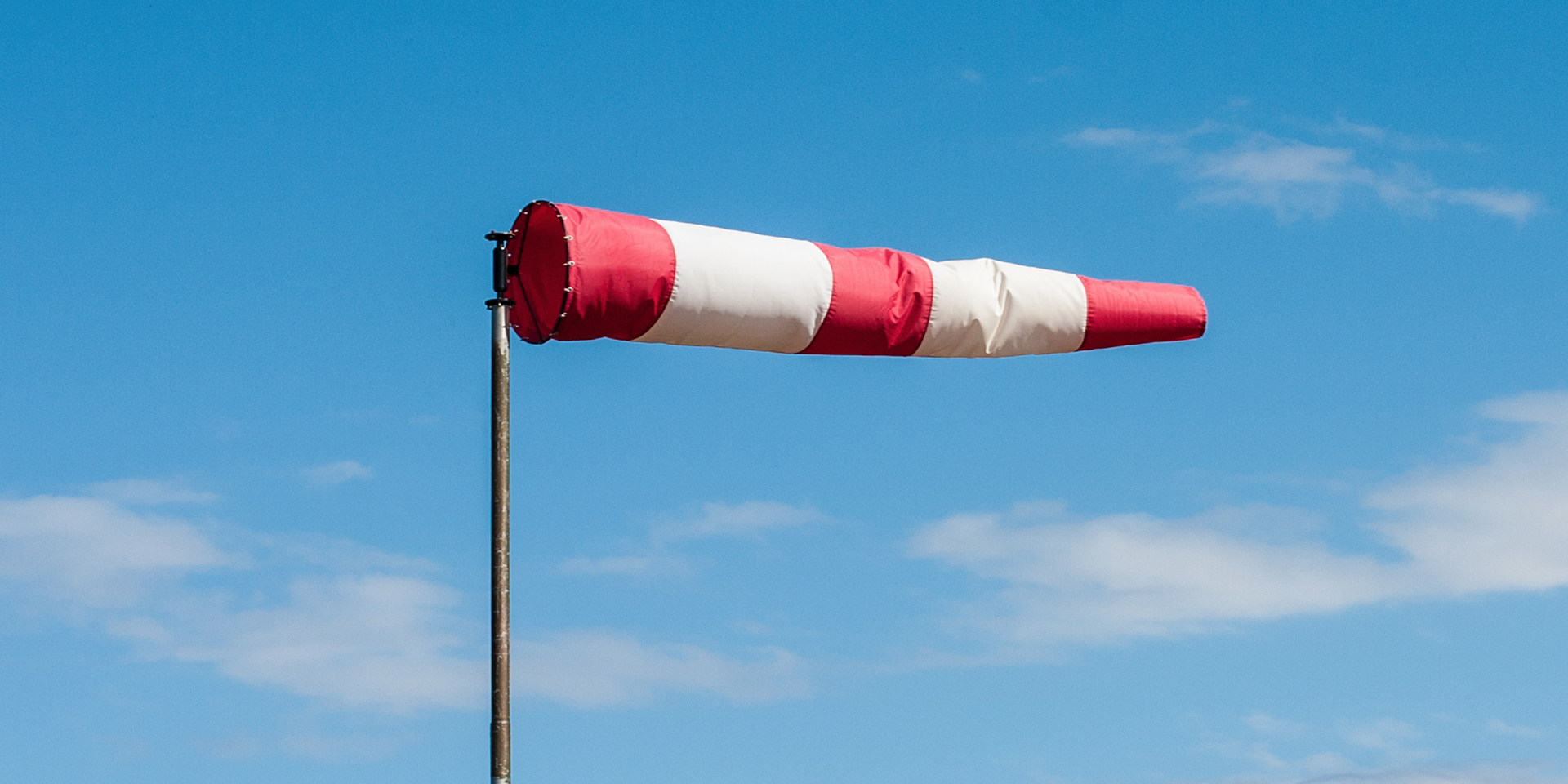 A wind sock blowing in the wind at an airport.