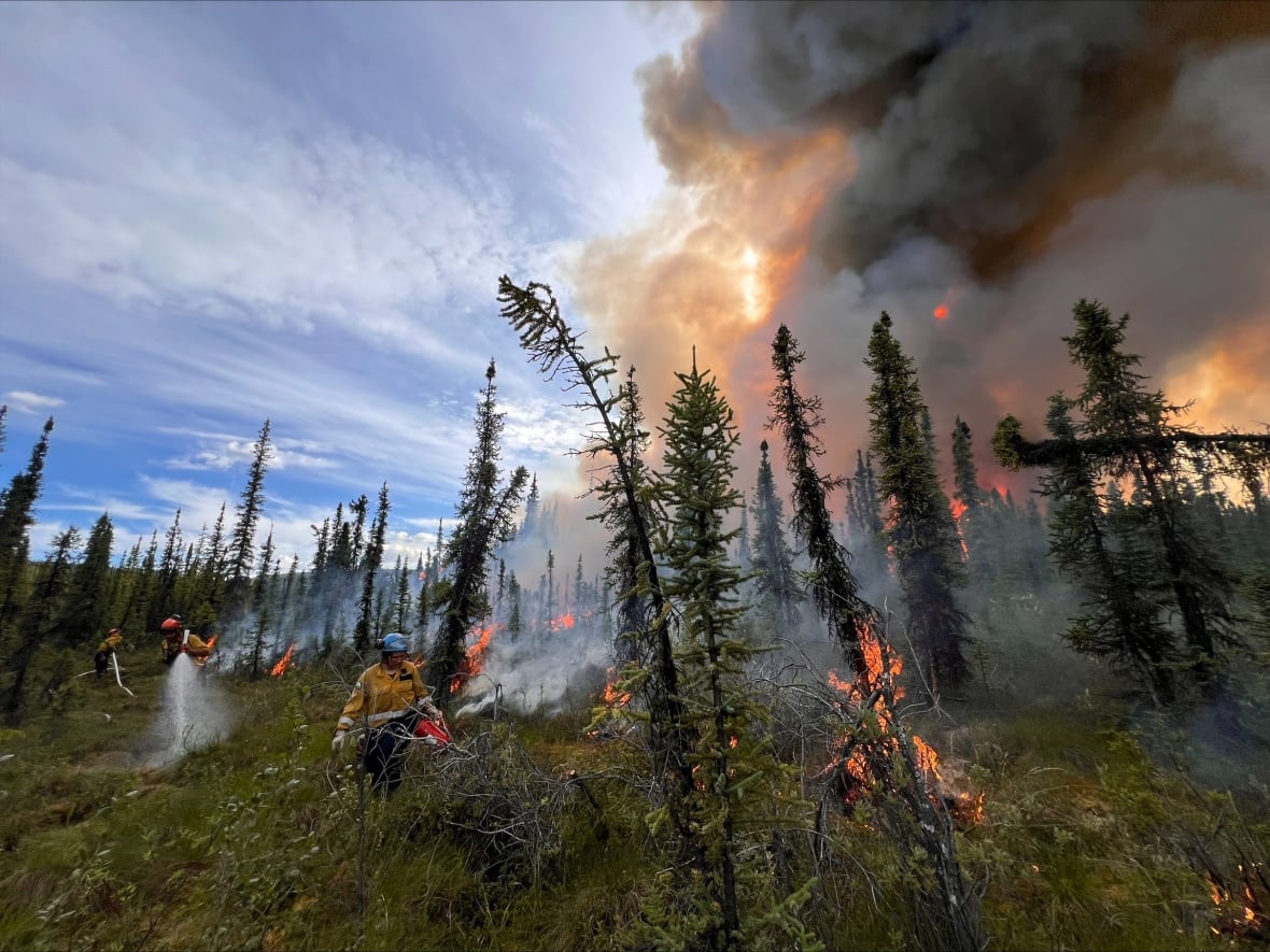 Firefighters work in the midst of flames and smoke.