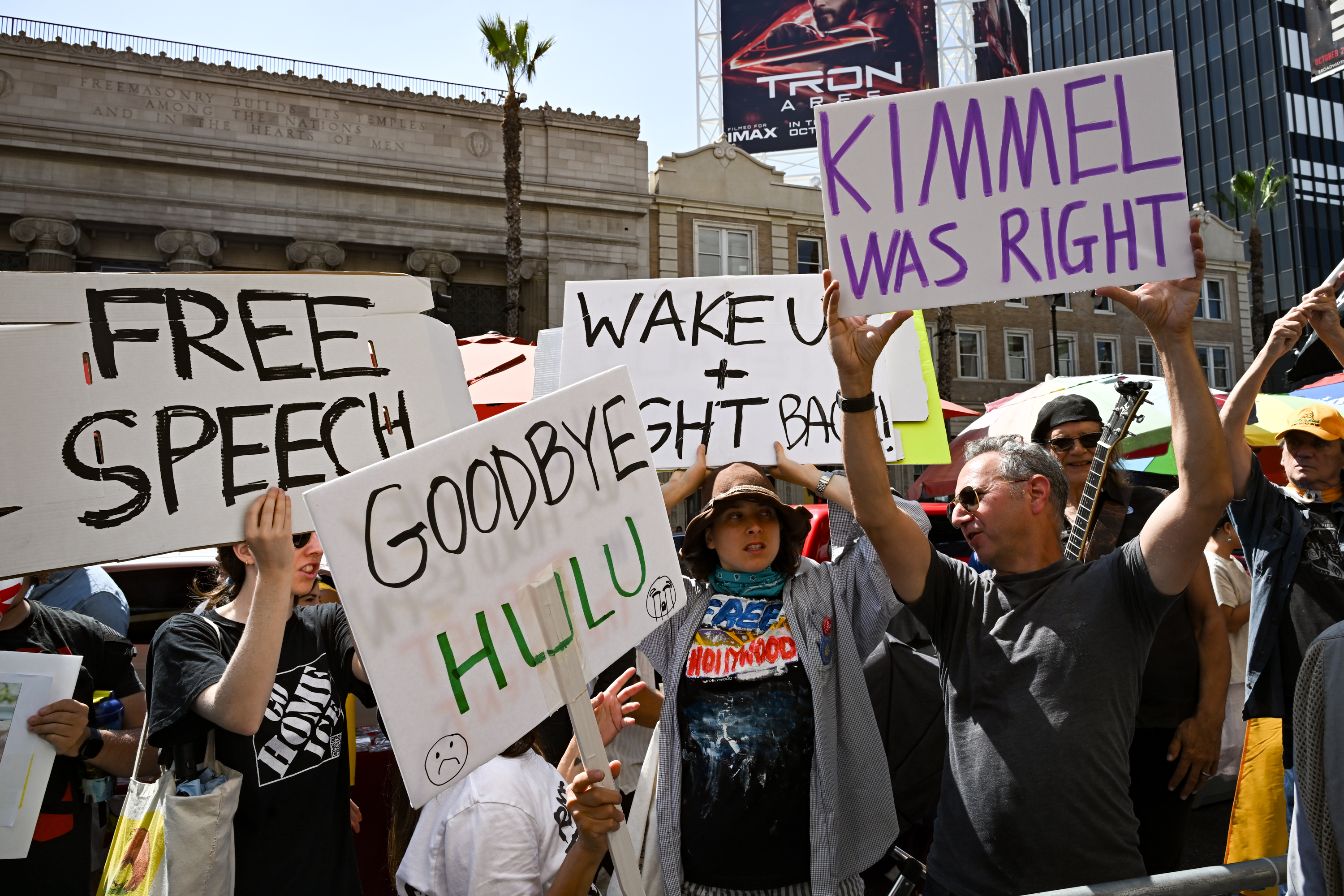 Protestors holding signs at a press conference regarding the suspension of "Jimmy Kimmel Live!"