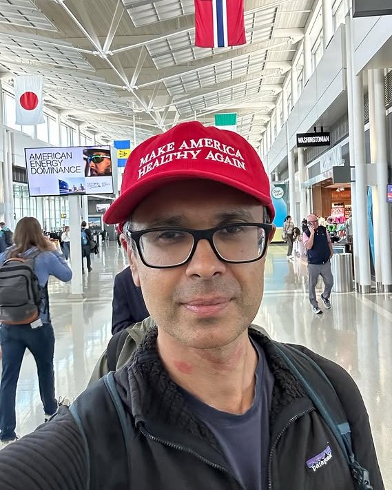 Dr. Aseem Malhotra wearing a "Make America Healthy Again" hat at an airport.