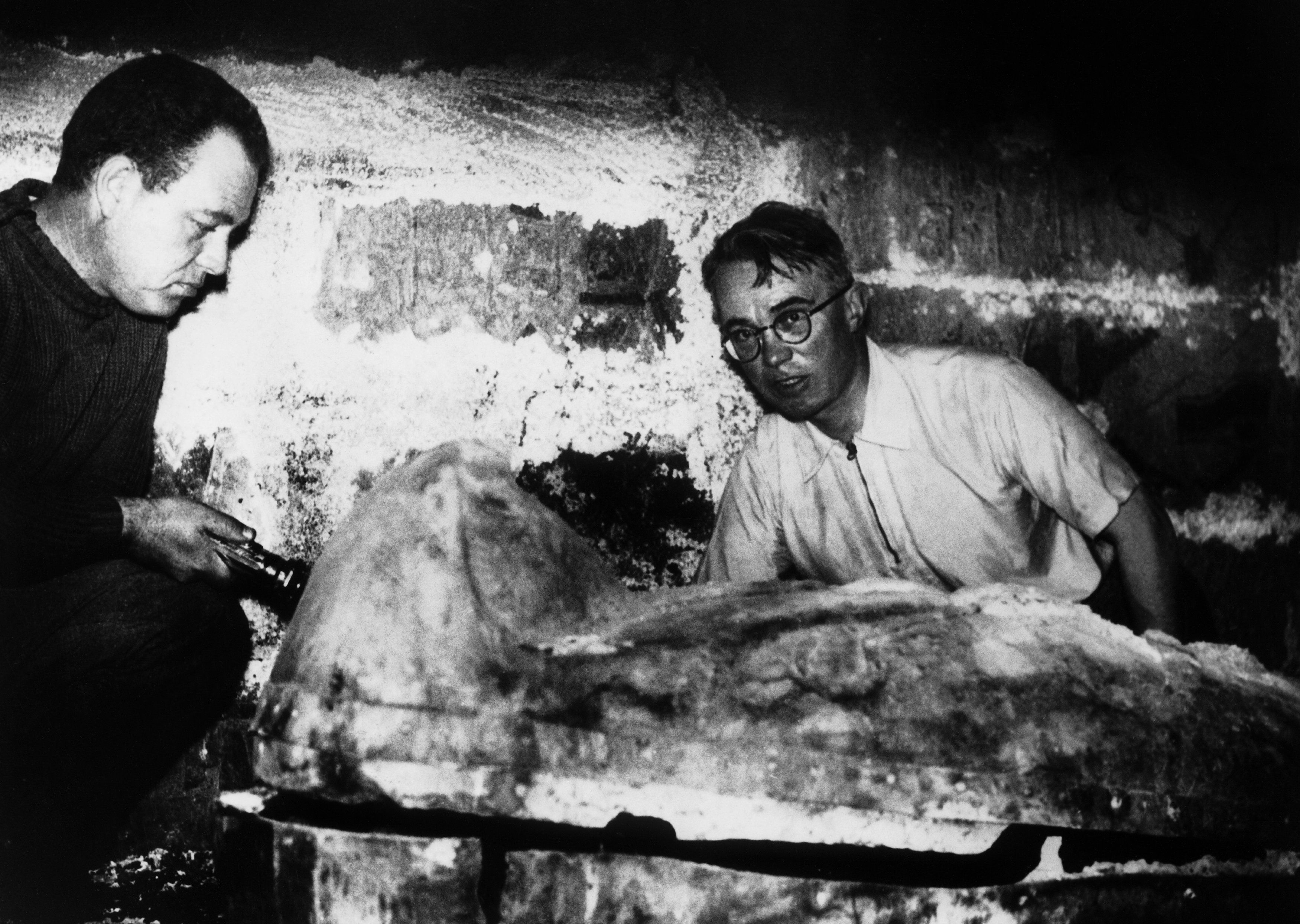 Black and white photo of archaeologists examining the silver sarcophagus of Pharaoh Psusennes II.