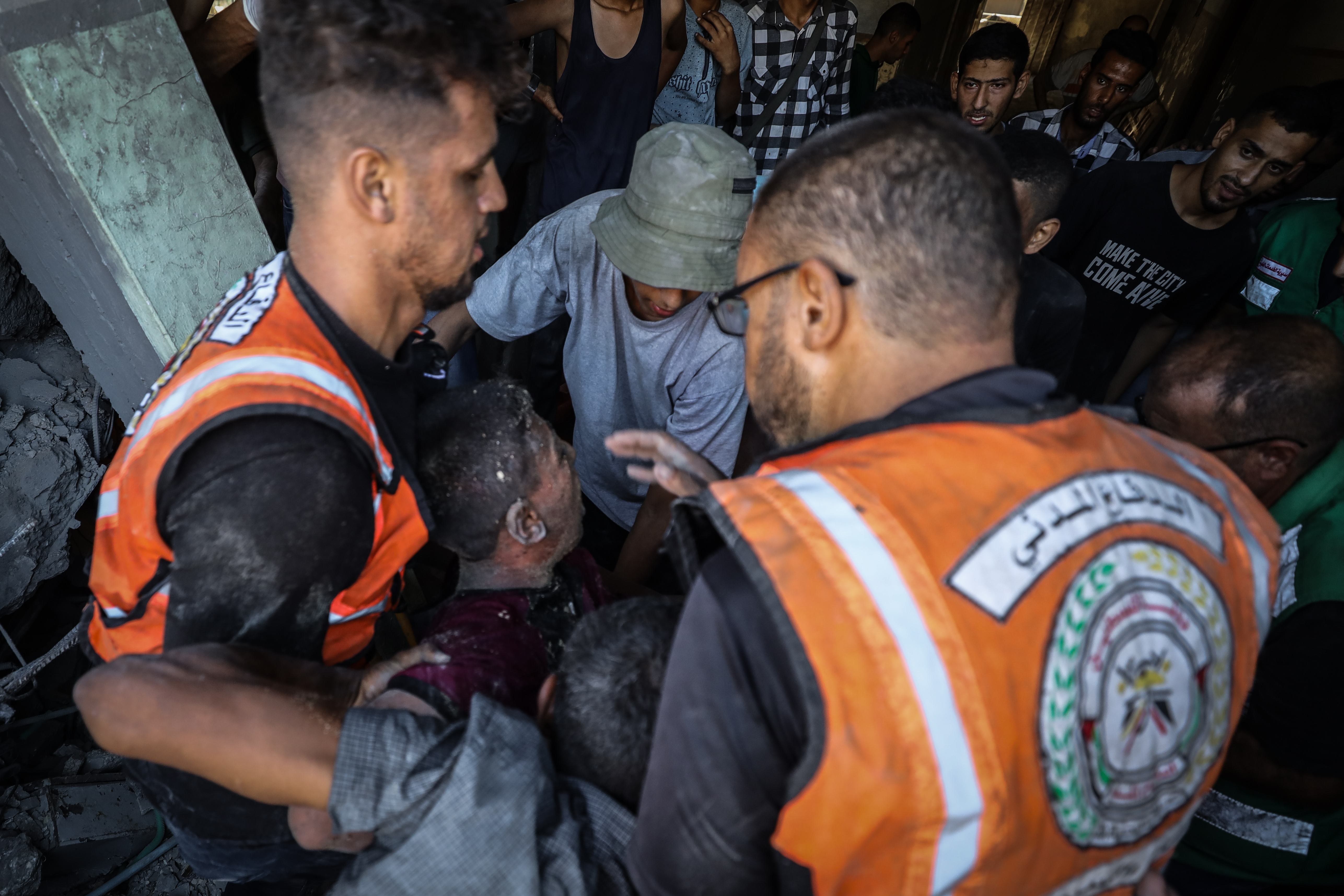 Rescue workers pull a person from rubble.